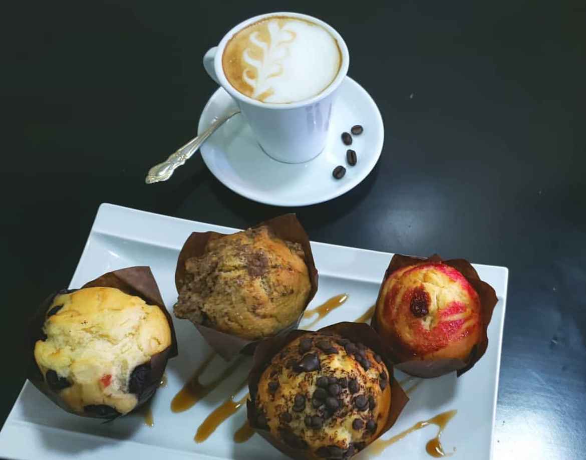 Taza de café con muffins sobre una mesa. Del Instagram @aromasdecafe