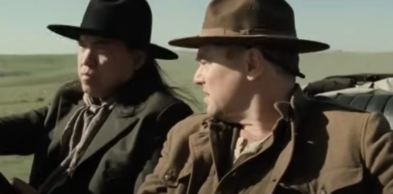 Captura de pantalla del trailer de la Película los Asesinos de la Luna disponible en https://www.youtube.com/watch?v=57yrWZt5z2g. En la imagen se ve al actor Leonardo Di Caprio conversando con el chofer que le lleva de la estación del tren a casa e su tío, el Actor Robert De Niro.